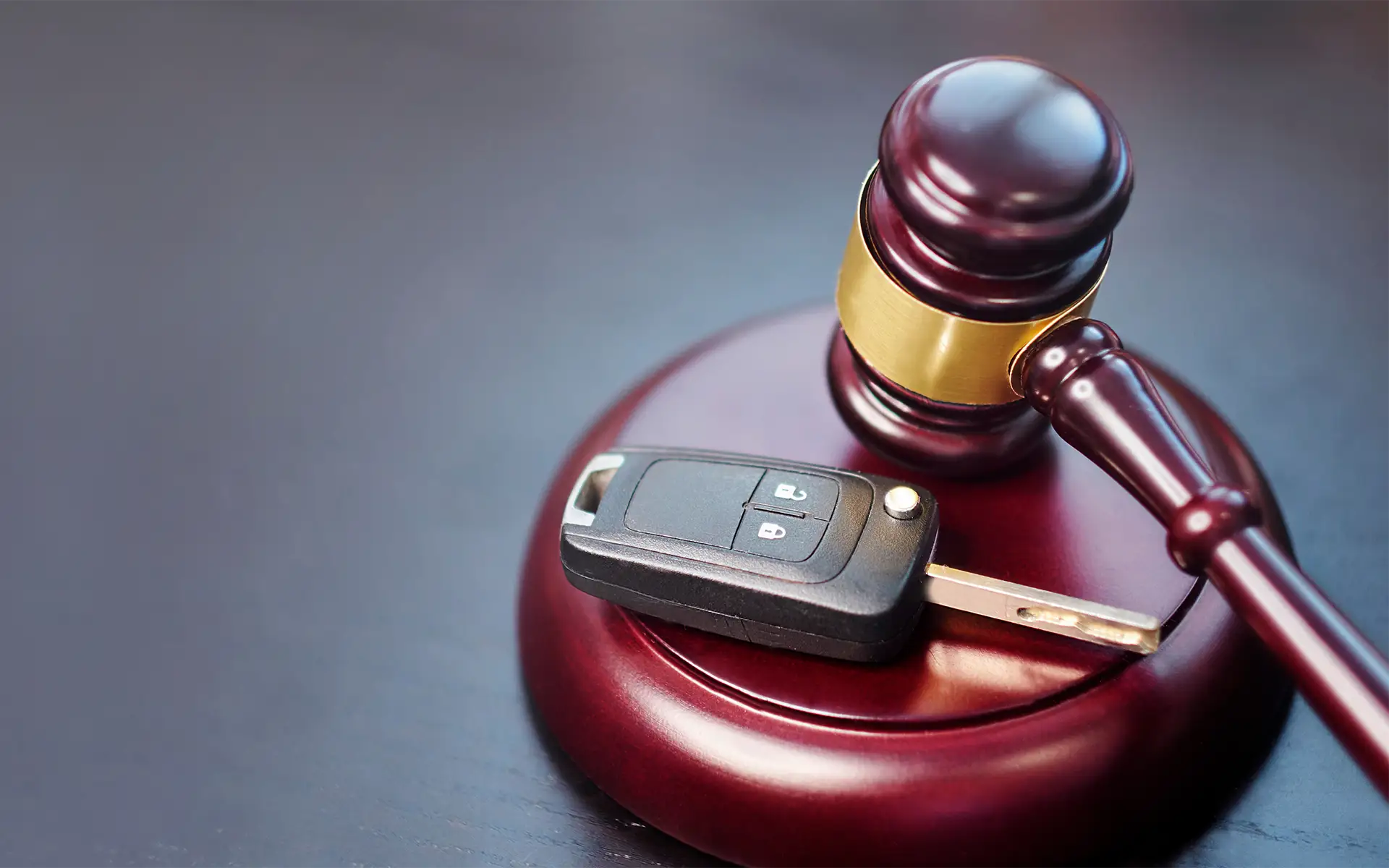 A judge's gavel on a table next to a car key representing a traffic ticket lawyer helping in court
