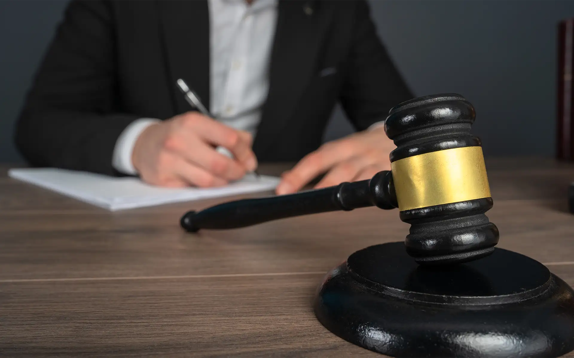 A fleeing and eluding attorney reviewing a case file at a table with a court gavel resting in front of him