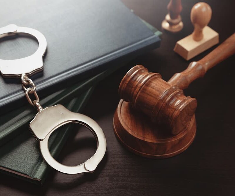 Handcuffs and a judge's gavel on law books, illustrating first-time felony charges in Texas.