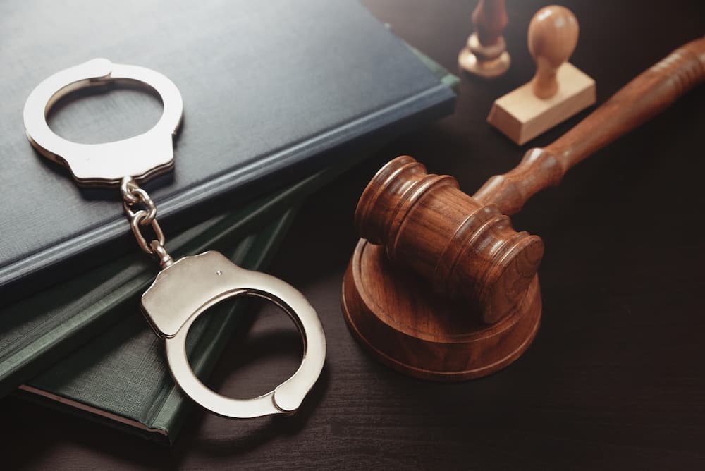 Handcuffs and a judge's gavel on law books, illustrating first-time felony charges in Texas.